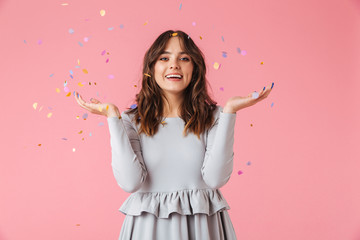 Happy brunette woman in dress posing and looking at camera