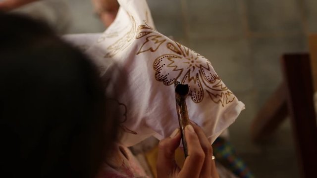 Detail of waxing the drawing to textile for making batik. Bali island.