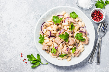 White bean tuna salad on concrete background. Top view, space for text.