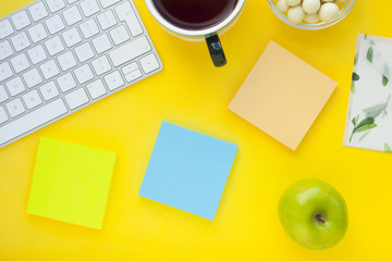 Set of colorful stickers, white keyboard, notebook and snacks. Office table, desk with different objects. Working process. Education, business concept.