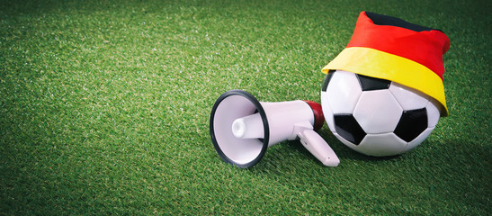 Fototapeta na wymiar Soccer ball with german fan cap and megaphone