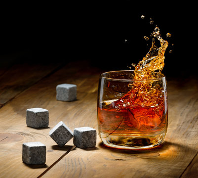Whiskey and whiskey stones on a wooden table.