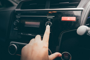 Woman Turning Button Of Radio In Car.