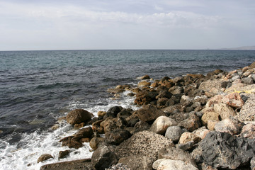 Fototapeta na wymiar The stone coast of the Mediterranean sea on the sunny day
