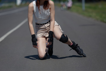unknown young girl fell on the road and bruised her knee during skating on warm sunny day