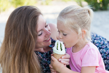 Mom and child eat ice cream, happy family moment.