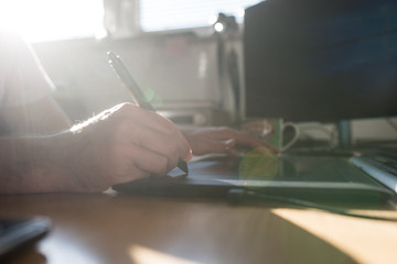 Graphic designer or illustrator using a tablet and stylus pen to do processing and drawing