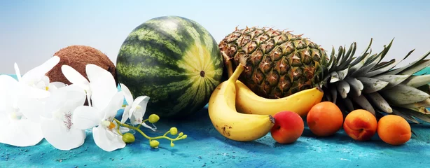 Wandaufkleber Tropical fruits background with pineapple, banana, coconut and watermelon © beats_