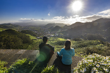 couple sitting with view on villages and teide volcano at sunset