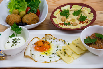 Traditional Arabic breakfast, lettuce, eggs, cheese, olives, and decorative vegetables, served on a plate, restaurant, service