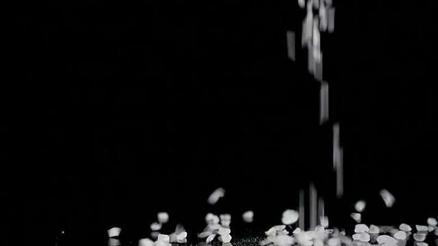 coarse sea salt crystal falling on black background