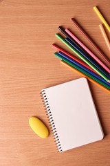 blank notebook page with colored pencils on table