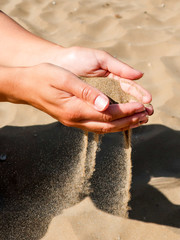 Beautiful picture of a woman's hands holding and pouring sand.