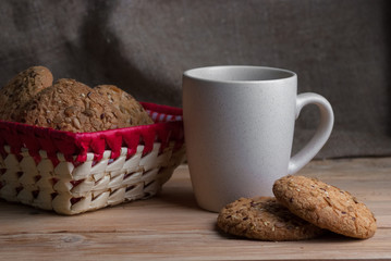 Oatmeal cookies with sunflower seeds near cup of tea.