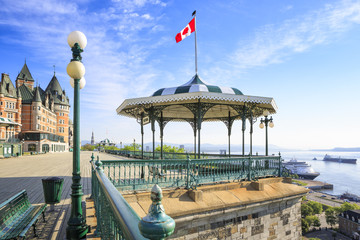 Fototapeta premium Miasto Quebec, Kanada. Wcześnie rano ujęcie Terrasse Dufferin z hotelem Chateau Frontenac w tle po lewej stronie. Brak osób. Statek wycieczkowy na molo poniżej rzeki Świętego Wawrzyńca.