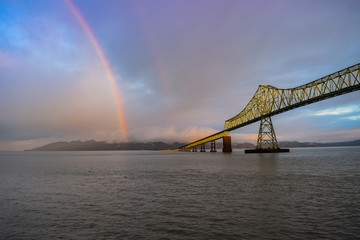 Fototapeta na wymiar Rainbow over river and bridge in Astoria, Oregon