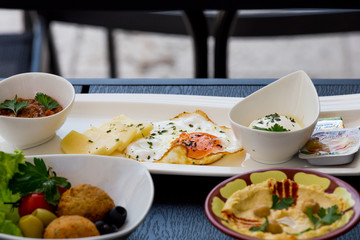 Traditional Arabic breakfast, lettuce, eggs, cheese, olives, and decorative vegetables, served on a plate, restaurant, service