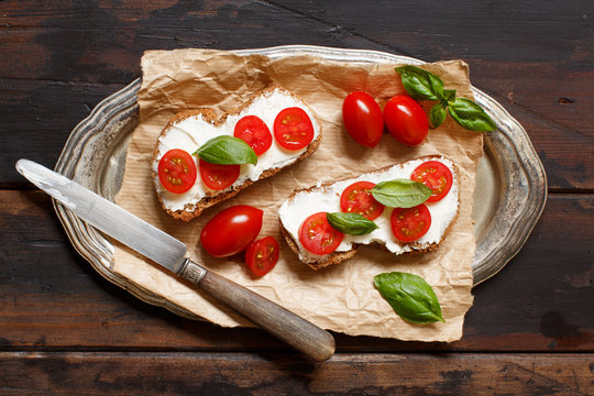 Bruschetta with cream cheese, cherry tomatoes and basil