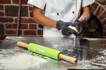 chef making dough for pizza. Man hands preparing bread. Concept of baking and patisserie