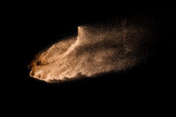 Golden sand explosion isolated on black background. Abstract sand cloud. Golden colored sand splash...