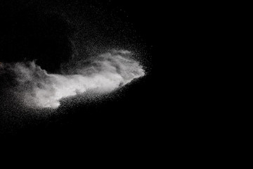Naklejka na ściany i meble Freeze motion of white particles on black background. Abstract white dust explosion.