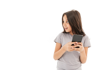 Fototapeta premium Cute girl standing isolated using mobile phone.