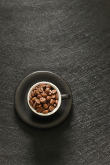 Cup of coffee beans isolated on black