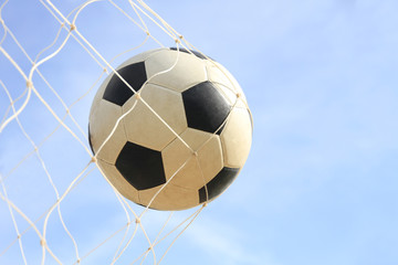 Soccer ball on net in goal