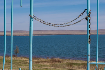 Fototapeta premium iron gate to the pond, closed with a chain with a padlock