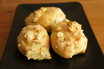 Three breads buns on black plate