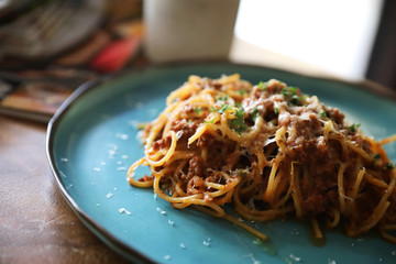 spaghetti Bolognese with minced beef and tomato sauce garnished with parmesan cheese and basil , Italian food