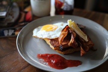 Breakfast french toast with bacon egg and cheese with jam on wood table background