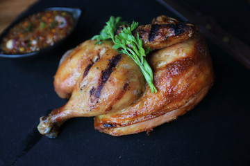 Grilled chicken on black dish wood background