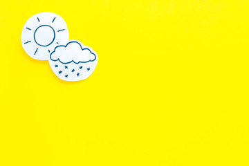 Clear and cloudly weather icons on yellow background top view copy space