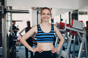 Fototapeta na wymiar Young woman exercising. Close up portrait image of attractive fit woman in fitness gym. Close up portrait of attractive fit girl.