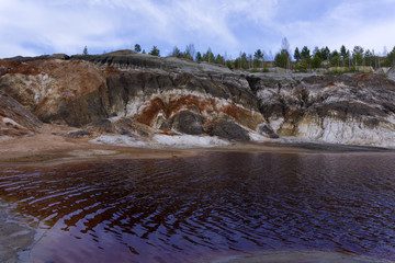 lake with red water with dissolved pyrite salts in the desert landscape of a spent quarry