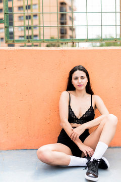 Sexy young woman sitting on ground in lingerie