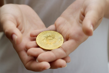 female hands closeup with the coin bitcoin