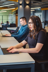 Female call center operator talking seriously on the headset