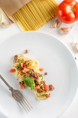 Delicious spaghetti with meat and tomato served on a white plate