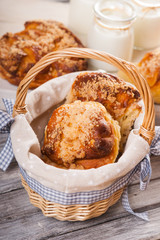 Bread buns in wicker basket and jars with milk