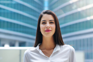 Fototapeta premium Portrait of a business woman, in a suit and tie, happy and smiling as she looks at the camera and crosses her arms, proud of her work. Concept of: success, finance and female career