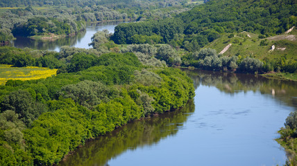Fototapeta na wymiar Landscape in the valley of the Don River in central Russia. Top view of the spring coastal forest and pond.