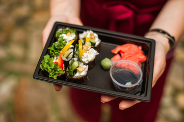  Sushi rolls. Close-up  of sushi rolls on black plate with soy sauce and ginger, top view. Sushi sets. Japanese food, vegan rolls.