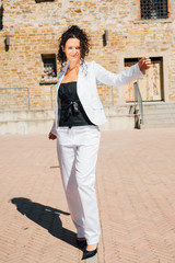 Young brunette wearing elegant tailleur. Summer season, sunny day.