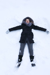 Fototapeta na wymiar Young woman laying on snow