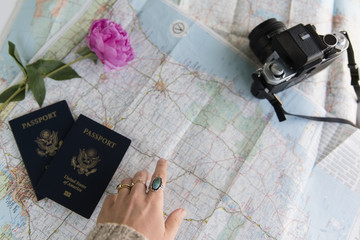 Passports, digital camera and flowers on map