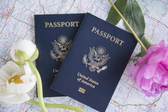 Passports and flowers lying on map