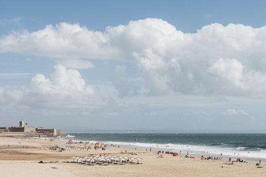 Portugal, Carcavelos, Puffy white clouds over beach
