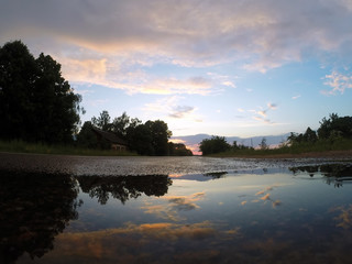 Fototapeta na wymiar The sky at sunset is reflected in a puddle,